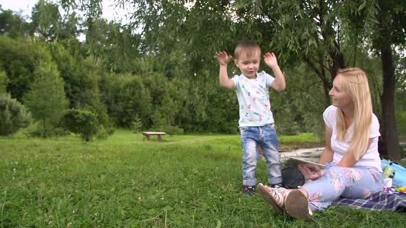 Young Mother and Little Son Spending Day in the Park