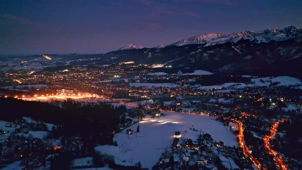 Illuminated Zakopane city at night in winter, aerial view