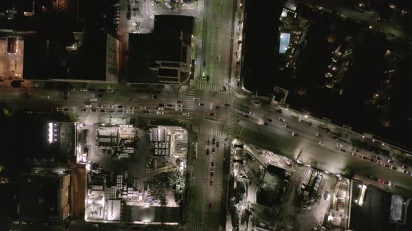 AERIAL: Overhead Rising on Intersection Street with Big Construction Site and Holes in Ground at