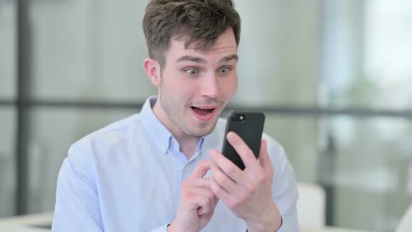 Portrait of Young Man Celebrating on Smartphone