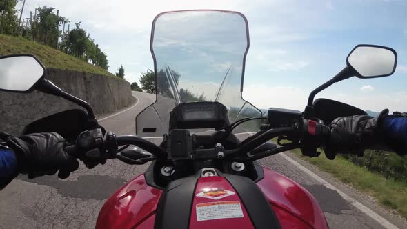 POV Biker Rides on a Motorbike Between Fields of Vineyards in Italy Countryside