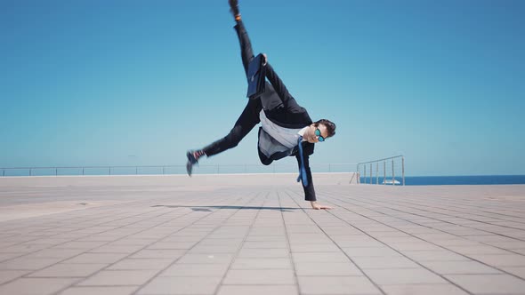 Flexible and cool businessman doing acrobatic tricks outdoor