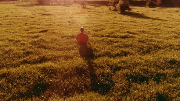 Low Altitude Radial Flight Over Sport Yoga Man at Perfect Green Grass. Sunset in Mountain.