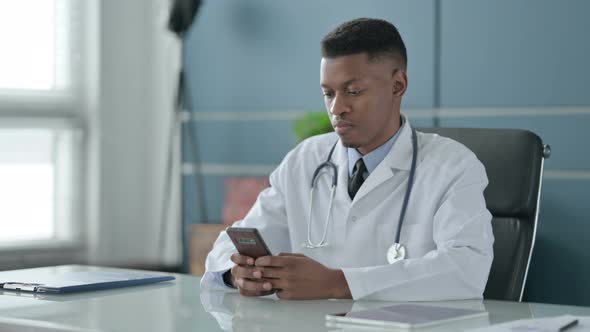 African Doctor using Smartphone in Office