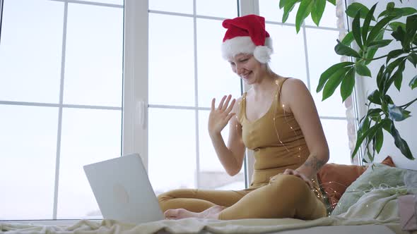 Young Woman in Santa Hat Talks Via Videocall Using Laptop