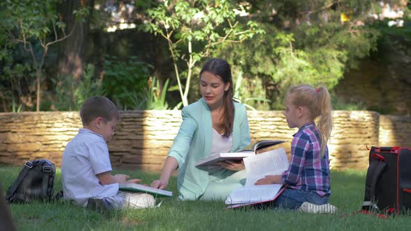 Modern Education Methods, Classmate Pupils Boy and Girl with Tutor Female Read Schoolbook and Chat