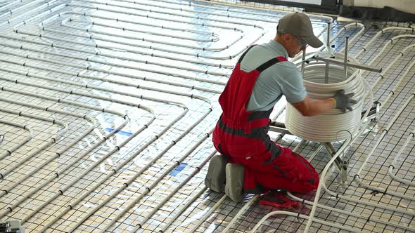 Floor Radiant Heating Systems installation Inside a House Performed by Professional HVAC Worker