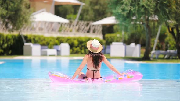 Young Woman in Bikini Air Mattress in the Big Swimming Pool