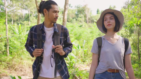 Young Asian man and Caucasian woman friend feeling fresh, walk and trave in the forest together.