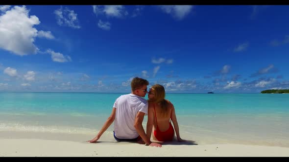 Man and woman tanning on tropical bay beach holiday by turquoise sea and bright sandy background of 