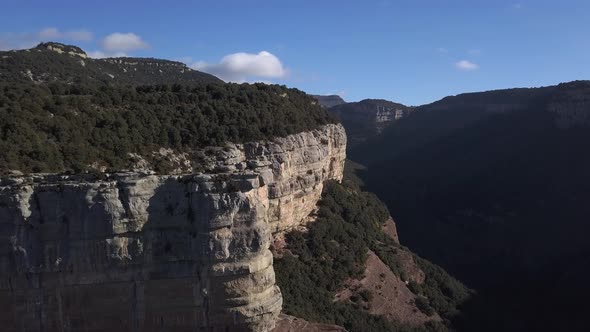 Aerial of steep tree covered cliffs with panoramic views, zooming shot