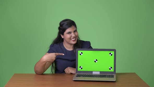 Young Overweight Beautiful Indian Businesswoman Against Green Background