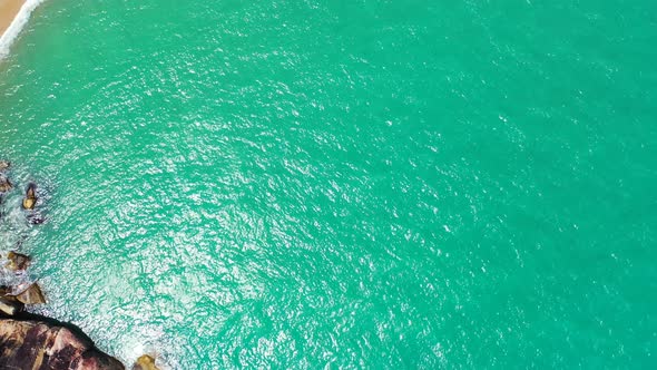 Aerial background. Emerald sea and golden sand beach wit palms leaning over the coast. Thailand