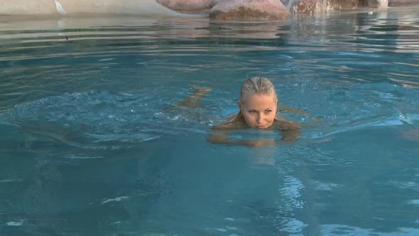 MS OF A WOMAN SWIMMING IN A POOL