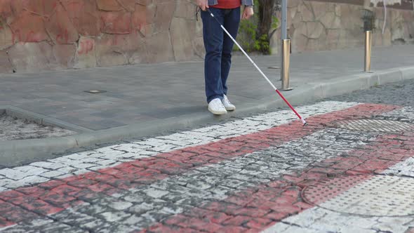 Young Blind Man with Using Safety Stick for Walking Alone Outdoors