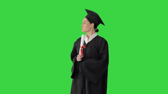 Female Student in Graduation Robe Holding Diploma and Waiving It Around on a Green Screen, Chroma