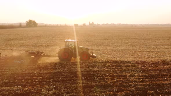 Tractor Plowing Field in Sunlit