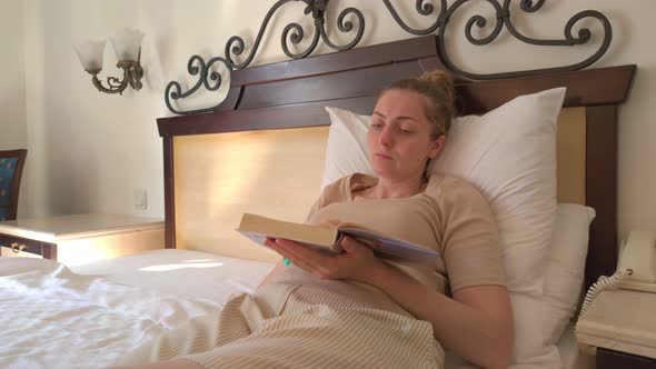 Woman Reading Book In Bed