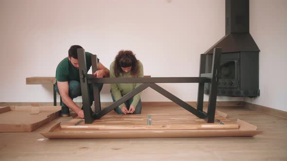 Couple Putting Together Self Assembly Furniture In New Home - wide shot