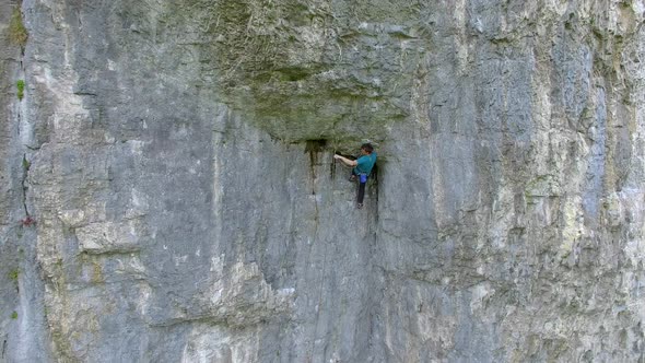 Aerial view of a man rock climbing up a mountain