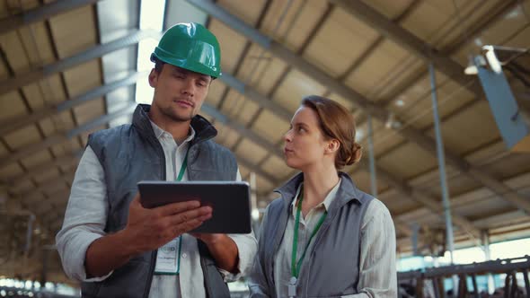 Animal Farmers Holding Tablet Computer in Shed