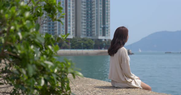 Woman sit at seaside and enjoy the view