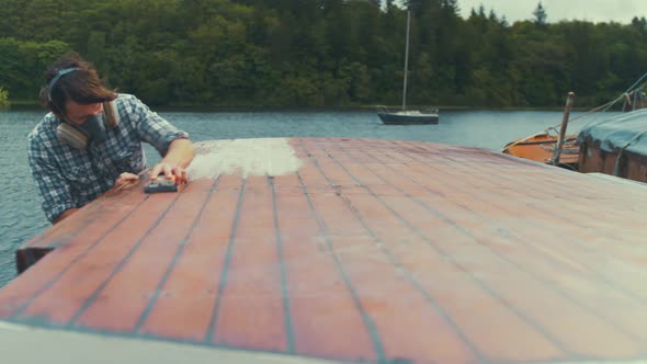 Sanding wood boat wheelhouse cabin by hand, WIDE SHOT