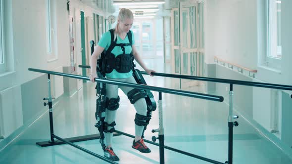 Young Woman is Using Exosuit for Walking in the Hospital