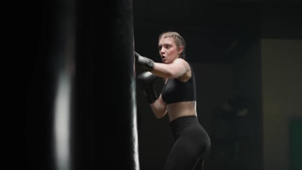 Athletic Female Fighter Trains His Punches Beats a Punching Bag Kickboxing Training Day in the