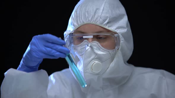 Toxic Laboratory Worker Studying Blue Fluid in Test Tube With Harmful Sign