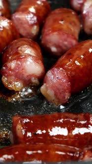 Delicious Fatty Hunting Sausages Cut Into Pieces are Fried in Frying Pan in Vegetable Oil