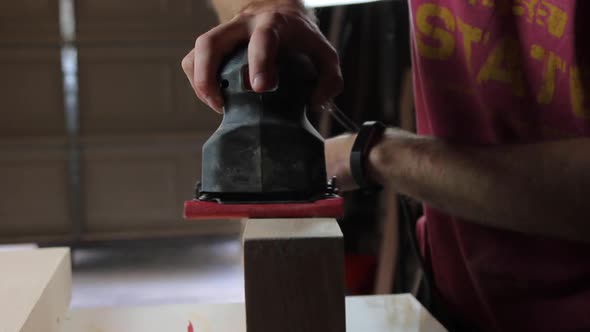 Finish sanding the wood filler on wooden floating shelves in preparation to be stained and hung in a