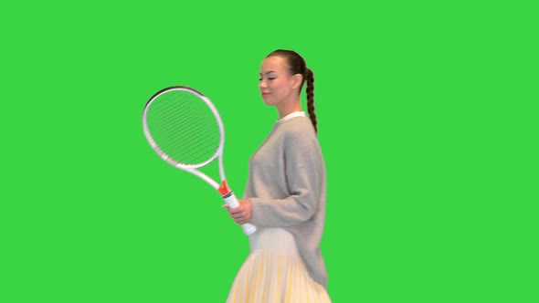 Young Woman with Tennis Racket Walking By on a Green Screen Chroma Key