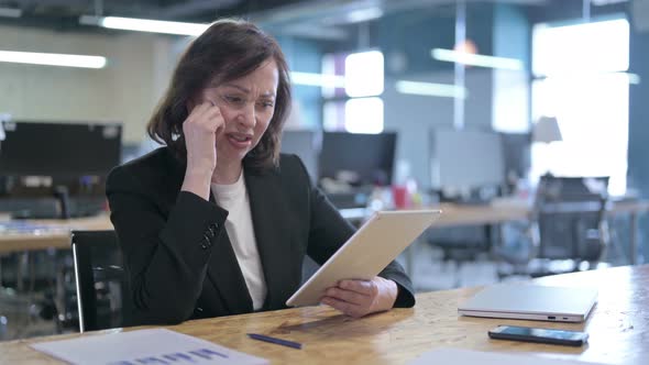 Shocked Businesswoman Reacting To Failure While Working on Tablet in Office