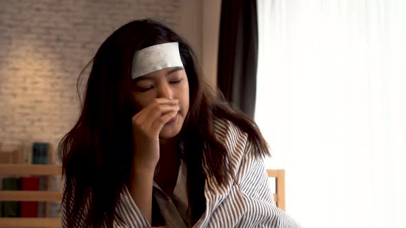 Young Asian Woman Suffering From Cold and Illness and Lying in Bed with Tissue at Home