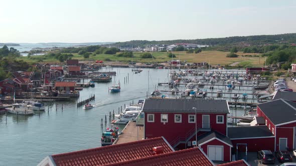 Small sea harbor with red buildings in aerial drone view. Sweden