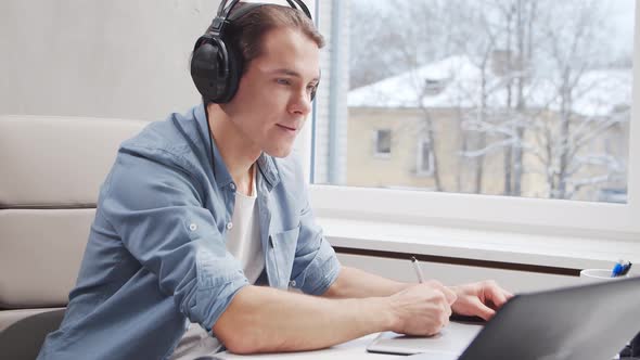 Workplace of freelance worker at home office. Young man works using computer.