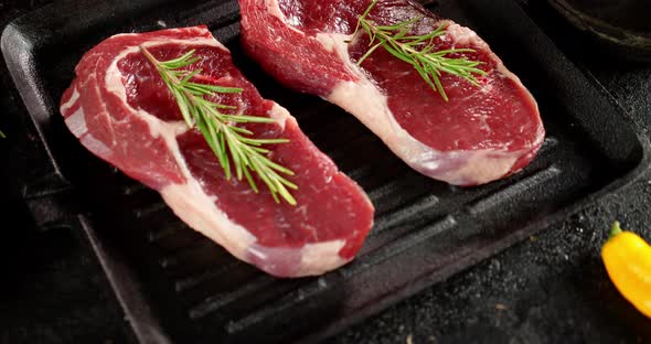 Raw Steak Beef Ribeye with Rosemary in a Frying Pan.