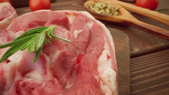 Fresh Raw Meat Steaks on Wooden Board with Spices Close Up