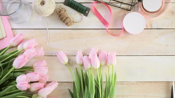 Step by step. Florist wrapping pink tulips in bouquet.