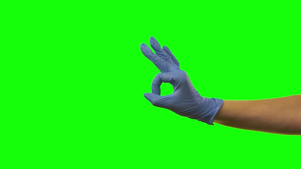 Doctors Female Hand in Blue Glove Is Making Gestures Ok. Green Screen. Close Up
