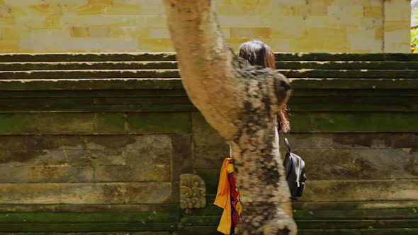 Teenage Chinese tourist explores a temple in Bali.