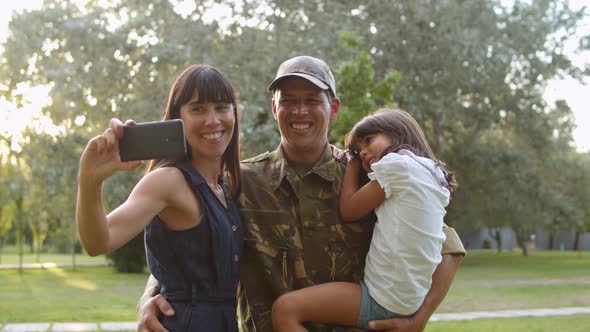 Happy Military Couple of Parents and Daughter Taking Selfie