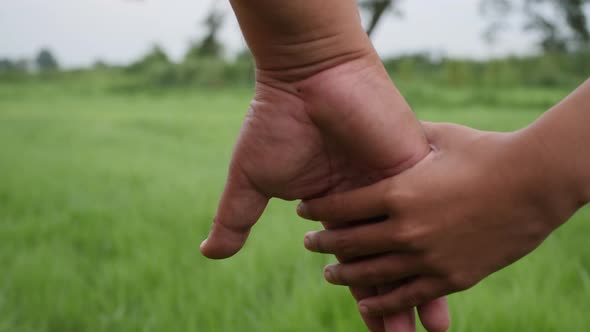 Close up hand of the father holding the daughter hand in slow motion scene