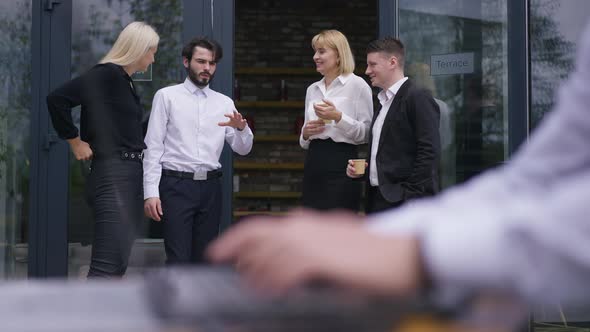 Relaxed Office Staff Talking on Terrace Outdoors Standing with Coffee Cups As Blurred Male Hands