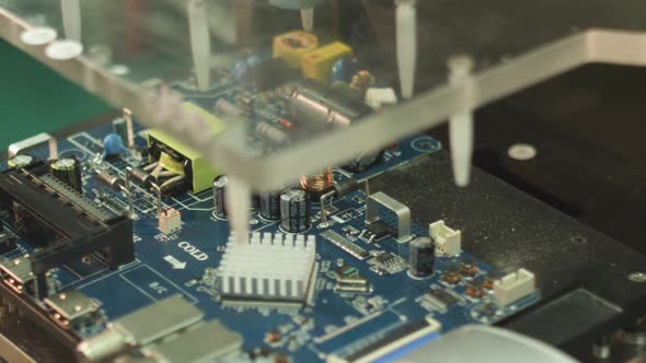 worker tests the main electronic board for a TV in a factory