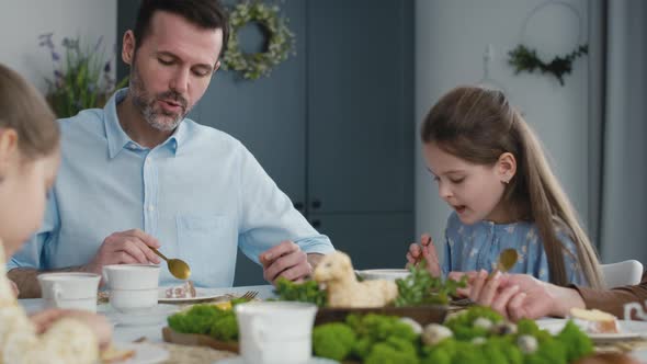 Caucasian family of four eating easter cake at the table. Shot with RED helium camera in 8K.