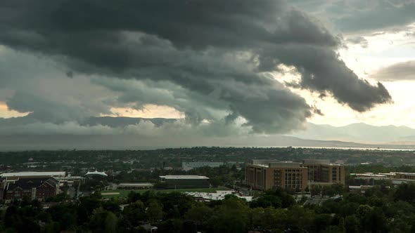 Time lapse of dark clouds moving fast over city kicking dirt into the air