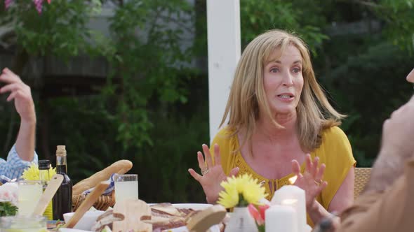 Senior woman talking while having lunch outdoors