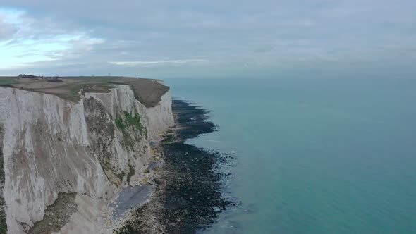 Aerial drone shot along the white cliffs of dover on a cloudy day